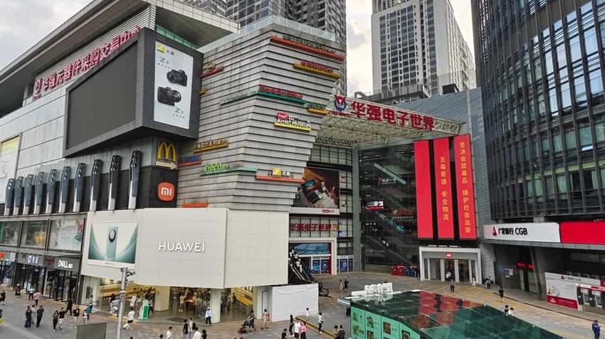 Huaqiang Electronics World building with Huawei, Xiaomi stores, busy plaza.