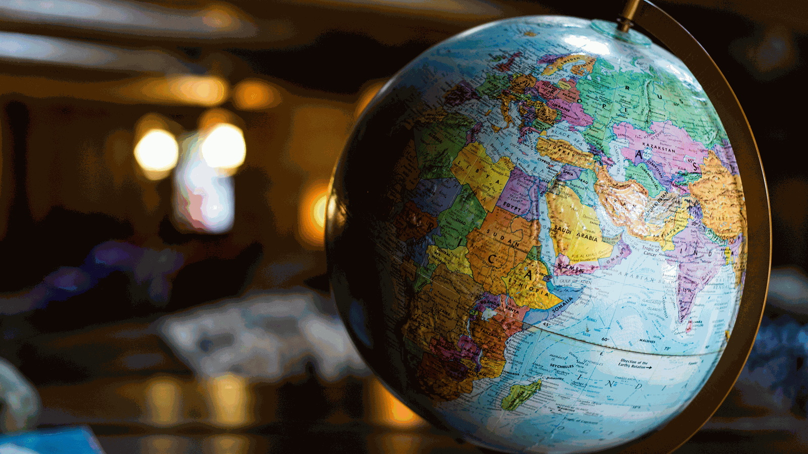 Close-up of a color-coded world globe (Africa/Asia/Europe) in warm light